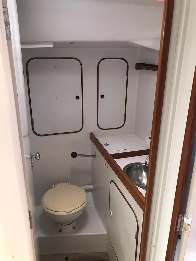 Slide: The Image of Compact bathroom in a 1991 Concordia Taylor 42 boat, featuring a toilet and sink. - 11