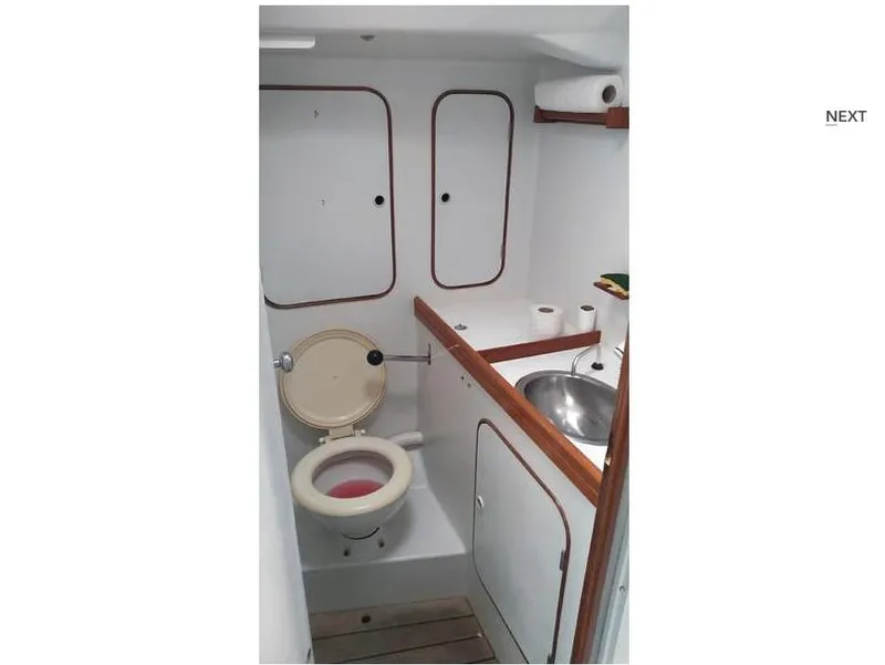 Slide: The Image of 1991 Concordia Taylor 42 yacht bathroom with toilet, sink, and storage cabinets. - 23