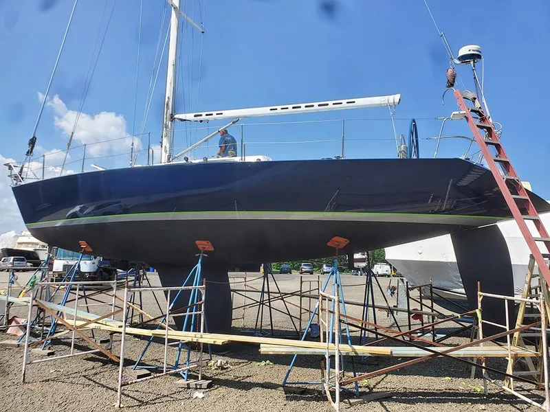 Slide: The Image of Sailboat Concordia Taylor 42, 1991 model, on dry dock with scaffolding and clear blue sky. - 7
