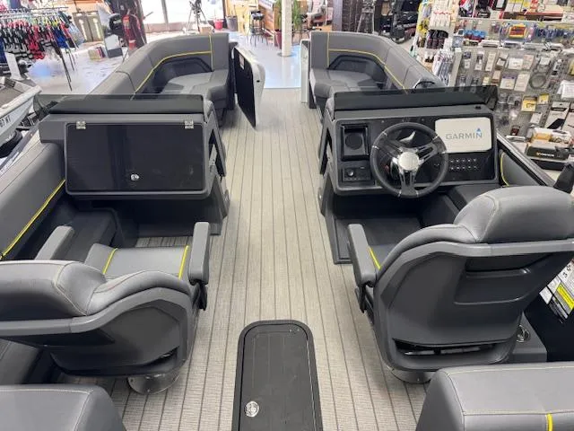Slide: The Image of 2025 Manitou Explore Navigator boat interior with modern seating and Garmin navigation system. - 2