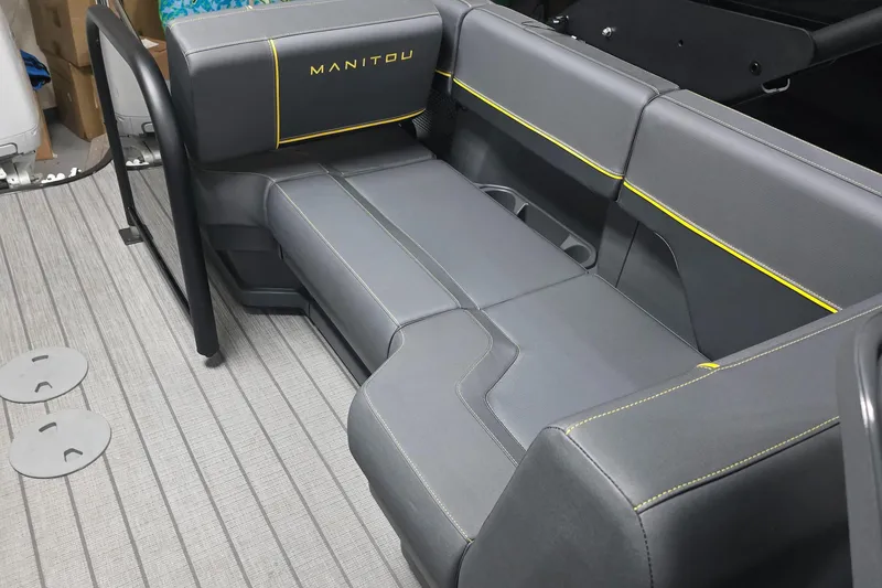 Slide: The Image of 2025 Manitou Explore Navigator boat seating with gray upholstery and yellow accents. - 6