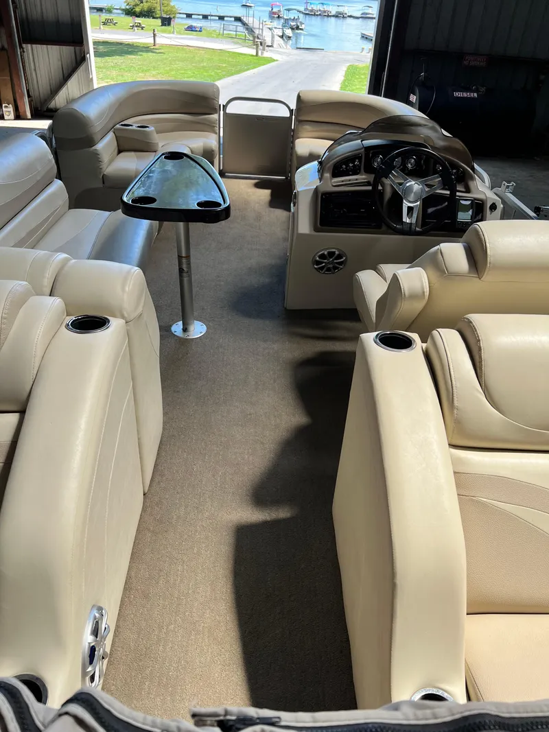 Slide: The Image of 2014 Bennington 2250 GSR pontoon boat interior with beige seating and steering console. - 3