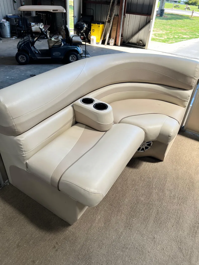 Slide: The Image of 2014 Bennington 2250 GSR boat seating with cup holders, beige upholstery, in a garage setting. - 5