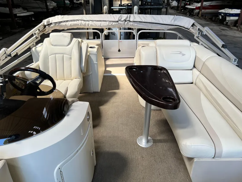 Slide: The Image of 2014 Bennington 2250 GSR pontoon boat interior with plush seating and steering console. - 7
