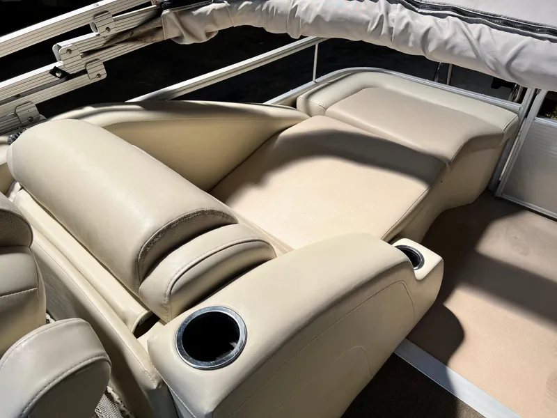 Slide: The Image of 2014 Bennington 2250 GSR boat interior with beige seating and cup holders. - 9