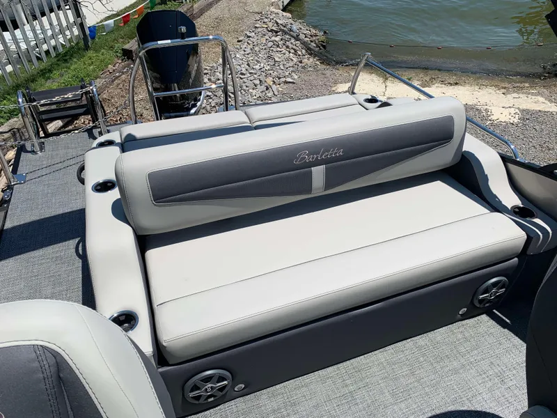 Slide: The Image of 2025 Barletta Cabrio 22UC boat with comfortable seating near a lakeside dock. - 19