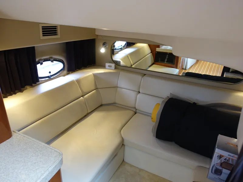 Slide: The Image of Interior of 2006 Regal 3560 Commodore yacht with beige seating and porthole windows. - 23