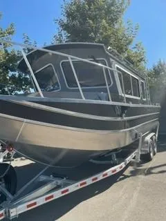 The Image of 2025 Spartan 2600 Olympia boat on trailer, parked outdoors under clear sky. - 0