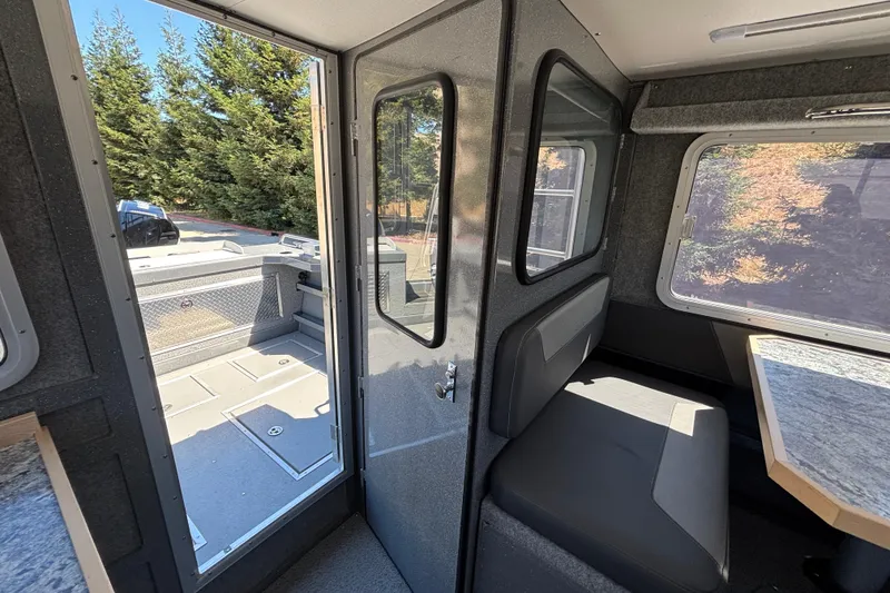 Slide: The Image of Interior view of 2025 Spartan 2600 Olympia boat, featuring seating and outdoor access. - 23