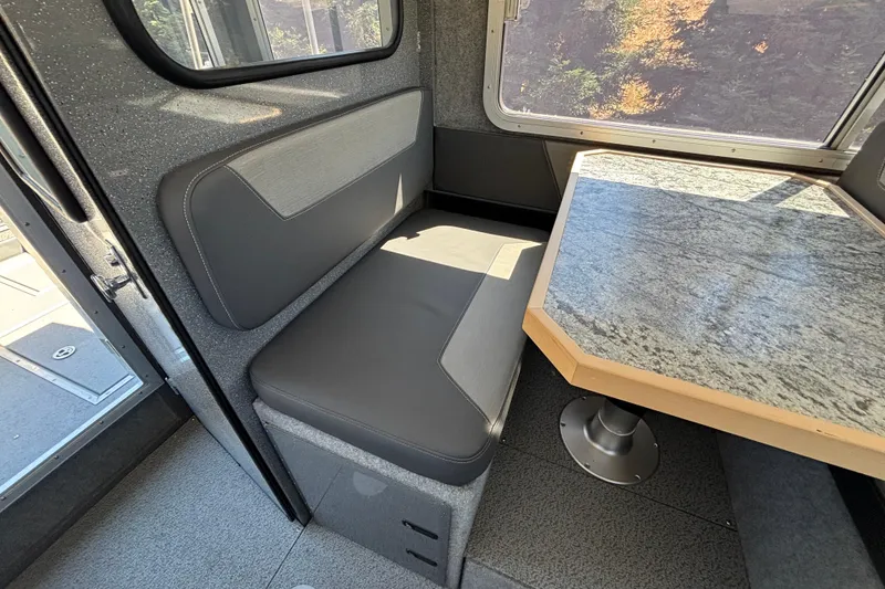 Slide: The Image of Interior of 2025 Spartan 2600 Olympia with gray seating and granite-style table. - 37