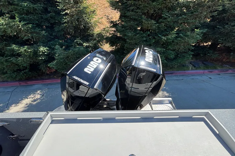 Slide: The Image of 2025 Spartan 2600 Olympia boat with dual Mercury outboard engines, surrounded by lush greenery. - 6