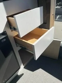 Slide: The Image of Open white drawers in a Spartan 2600 Olympia, 2025 model, showcasing interior storage space. - 25