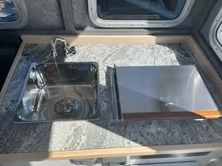 Slide: The Image of Compact kitchen area in 2025 Spartan 2600 Olympia RV with sink and stove. - 28