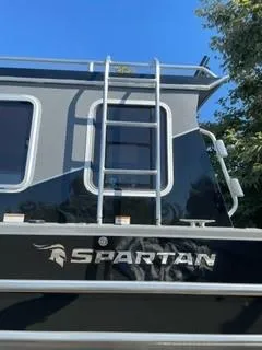Slide: The Image of 2025 Spartan 2600 Olympia boat with ladder and logo, under clear blue sky. - 3
