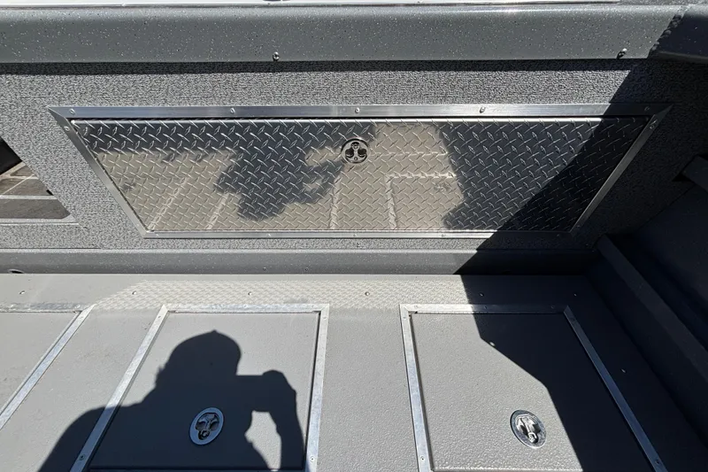 Slide: The Image of Interior of 2025 Spartan 2600 Olympia boat with diamond plate panel and storage compartments. - 15