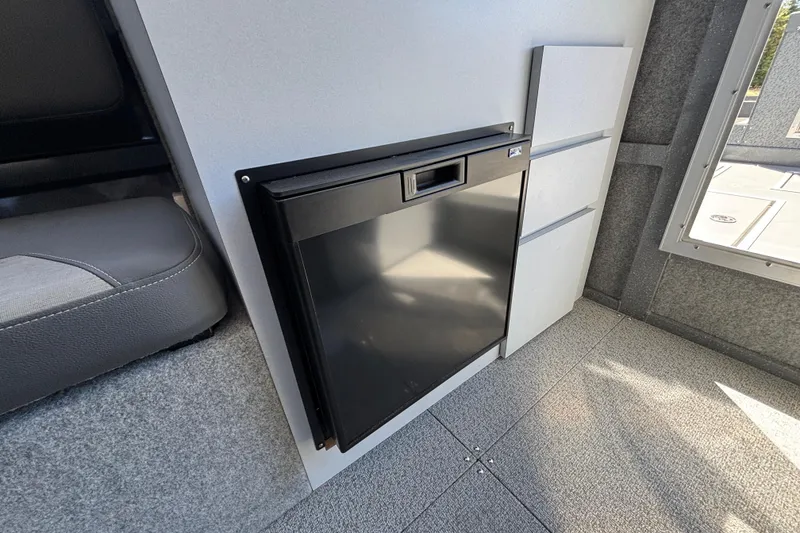 Slide: The Image of Compact interior of 2025 Spartan 2600 Olympia with sleek black mini-fridge and modern seating. - 34