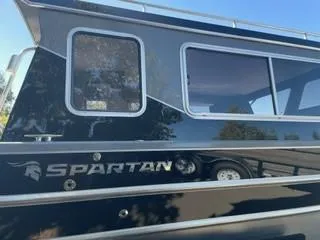 Slide: The Image of 2025 Spartan 2600 Olympia boat with sleek black exterior and large windows. - 5