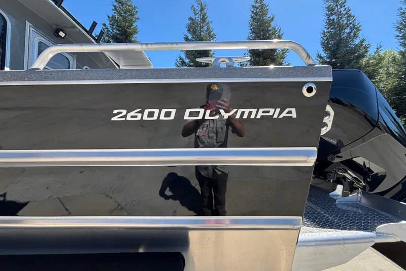 Slide: The Image of 2025 Spartan 2600 Olympia boat with sleek black exterior and chrome accents. - 4