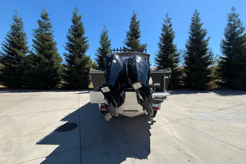 Slide: The Image of Rear view of 2025 Spartan 2600 Olympia boat with dual engines, parked outdoors. - 7