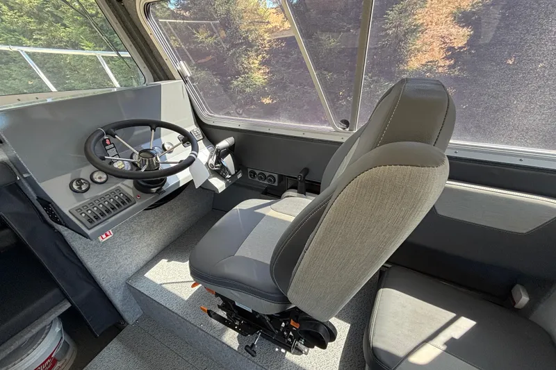 Slide: The Image of Interior of 2025 Spartan 2600 Olympia boat, featuring steering wheel and captain's chair. - 20