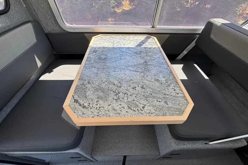 Slide: The Image of Interior of 2025 Spartan 2600 Olympia RV with granite table and black seating. - 32