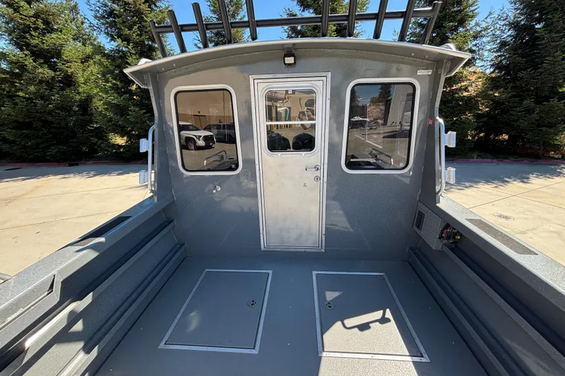 Slide: The Image of Interior view of 2025 Spartan 2600 Olympia boat, showcasing cabin door and seating area. - 11