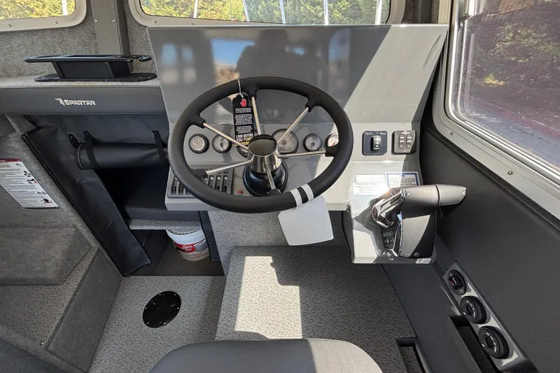 Slide: The Image of Cockpit of 2025 Spartan 2600 Olympia boat with steering wheel and control panel. - 19