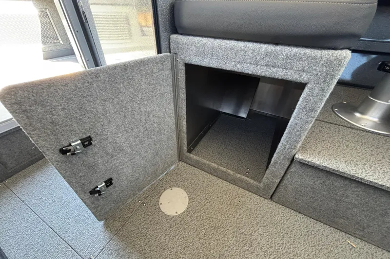 Slide: The Image of Interior storage compartment in 2025 Spartan 2600 Olympia, featuring carpeted finish and open door. - 45