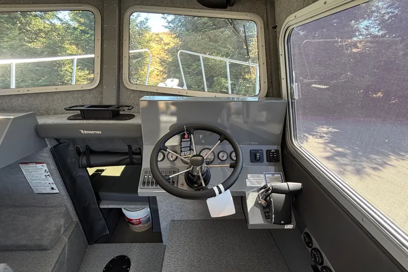 Slide: The Image of Interior of 2025 Spartan 2600 Olympia boat, featuring steering wheel and control panel. - 21