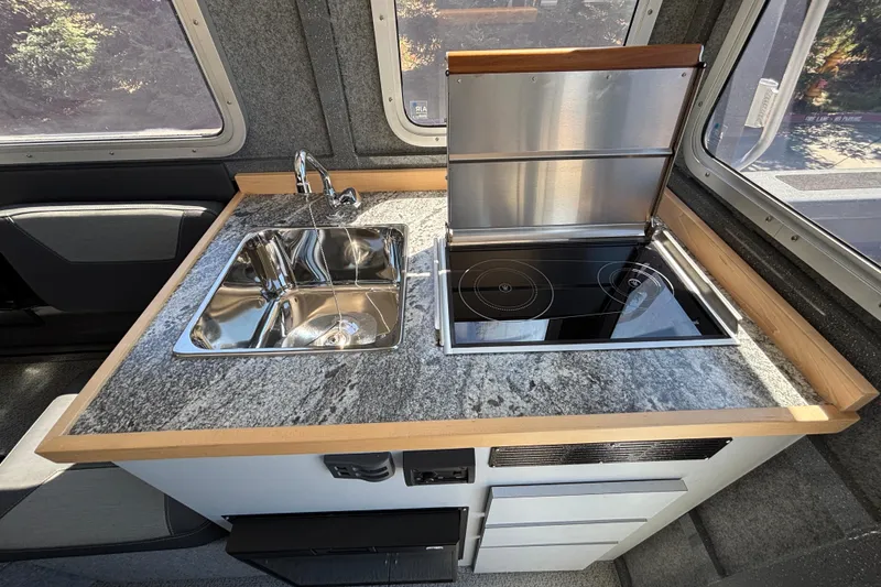 Slide: The Image of Modern kitchen in 2025 Spartan 2600 Olympia RV with sink and induction cooktop. - 33