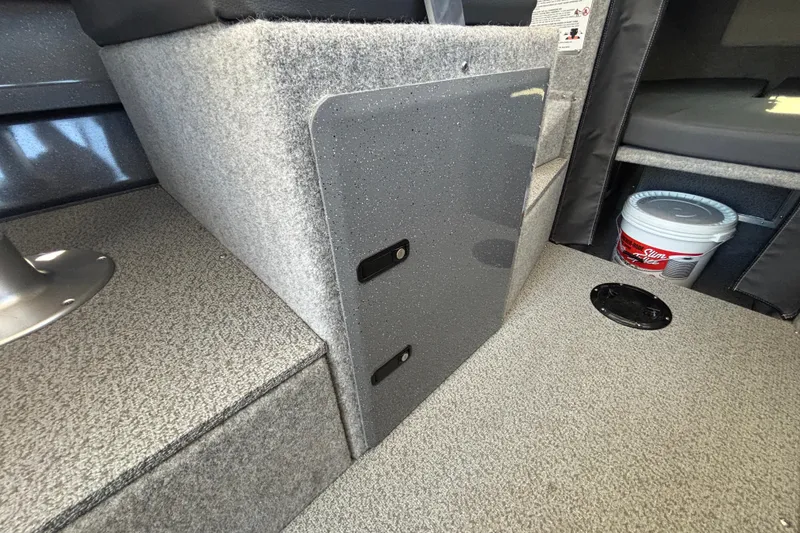 Slide: The Image of Interior of 2025 Spartan 2600 Olympia boat, featuring carpeted flooring and storage compartment. - 41