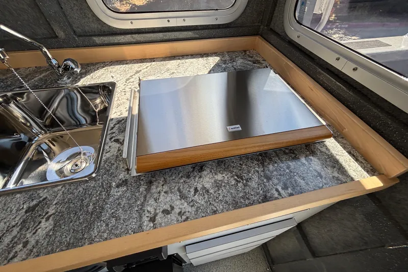 Slide: The Image of Modern kitchen setup in 2025 Spartan 2600 Olympia RV with stainless steel sink and countertop. - 36