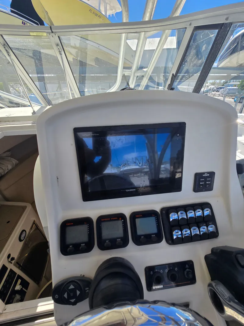 Slide: The Image of Control panel of a 2015 Sailfish 270 WAC boat with navigation screens and controls. - 12