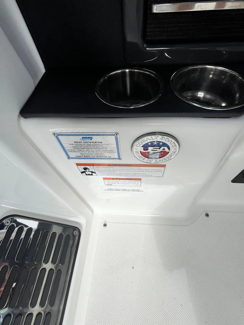 Slide: The Image of 2022 Cobalt A29 boat interior with cup holders and safety labels. - 20