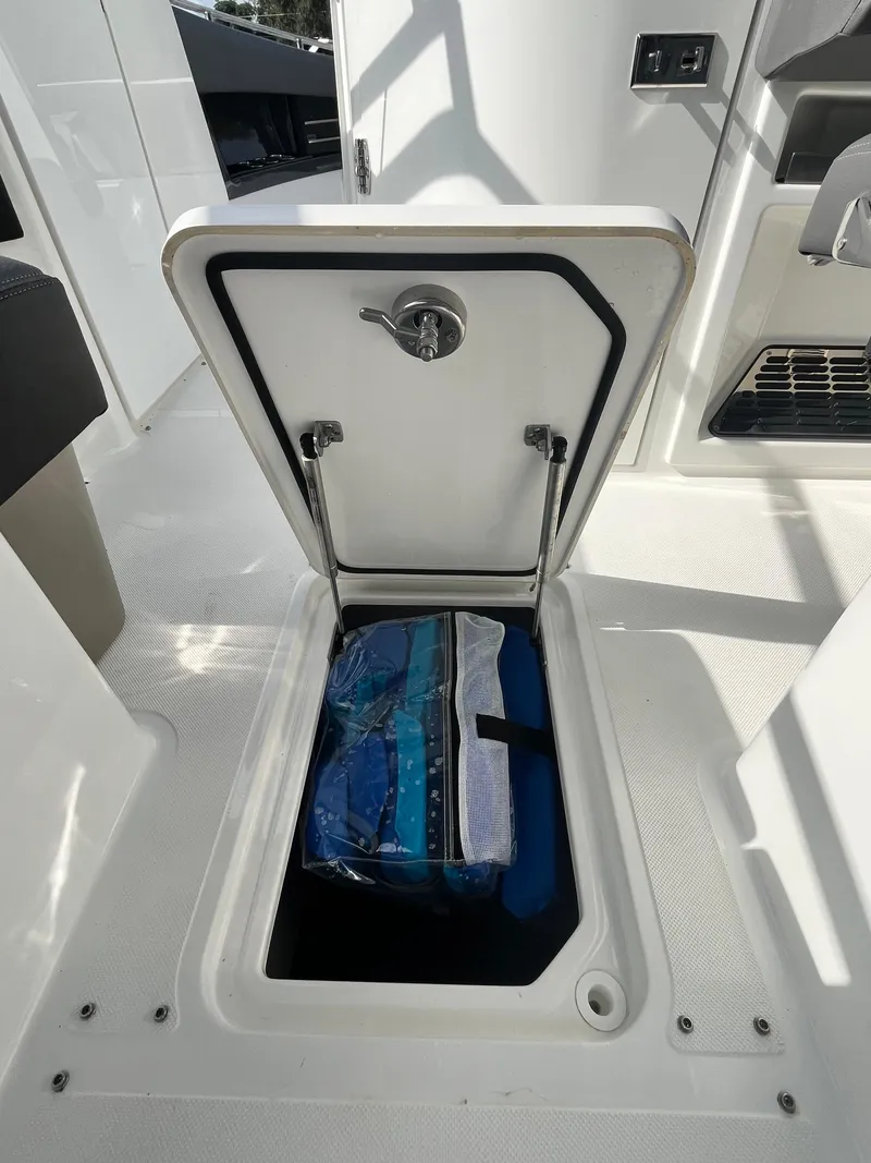 Slide: The Image of Storage compartment on 2022 Cobalt A29 boat, open with items inside. - 22