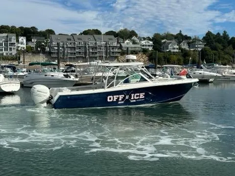 Slide: The Image of 2016 Sailfish 325 DC boat named "OFF ICE" in a marina with waterfront homes. - 13