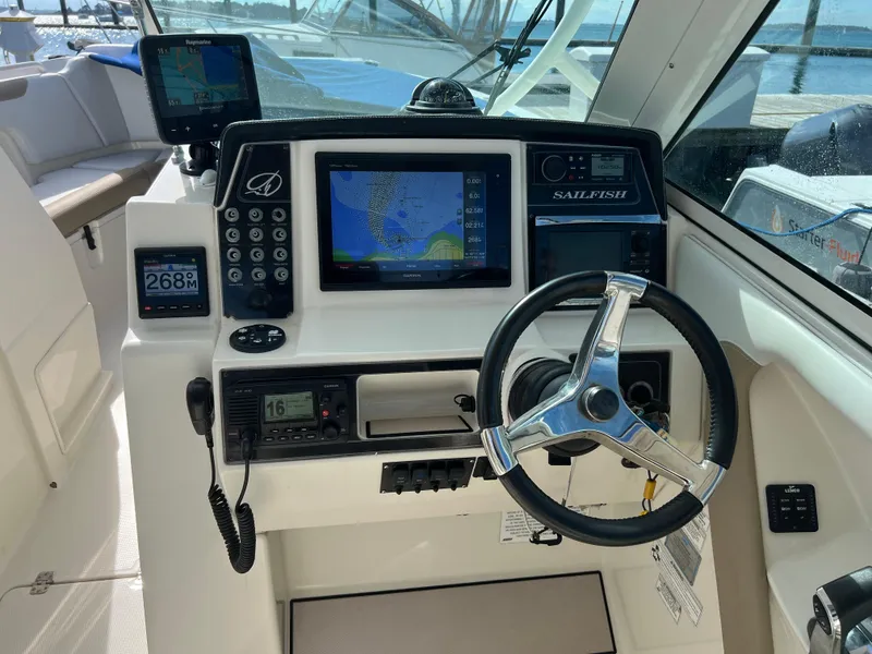 Slide: The Image of 2016 Sailfish 325 DC boat dashboard with navigation screens and steering wheel. - 14