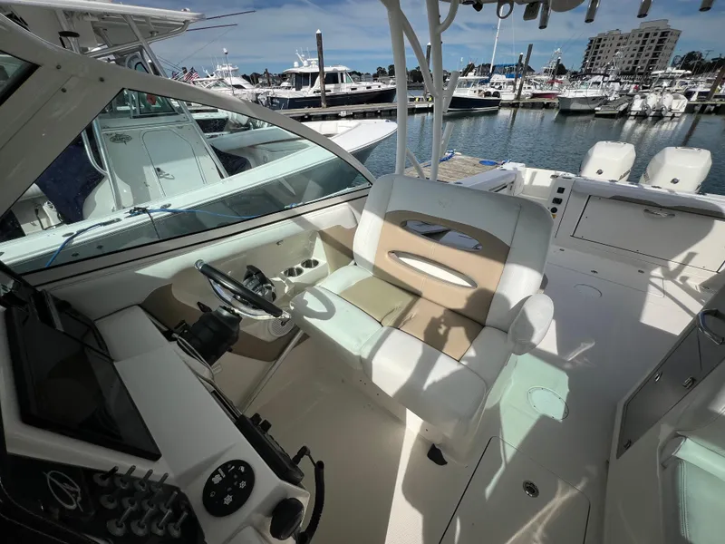 Slide: The Image of 2016 Sailfish 325 DC boat interior with helm, seating, and marina view. - 15