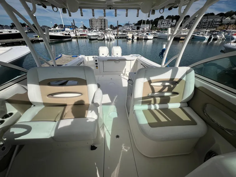 Slide: The Image of 2016 Sailfish 325 DC boat interior with seating, docked at a marina. - 16
