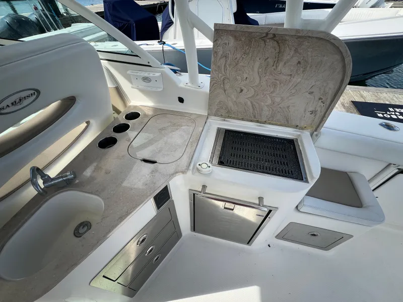 Slide: The Image of 2016 Sailfish 325 DC boat interior with sink, grill, and storage compartments. - 18
