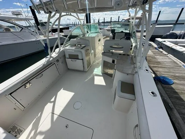Slide: The Image of 2016 Sailfish 325 DC boat interior with seating and storage, docked at marina. - 19