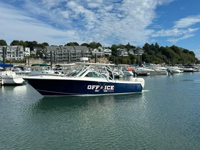 Slide: The Image of 2016 Sailfish 325 DC boat named "OFF ICE" docked in a marina. - 2
