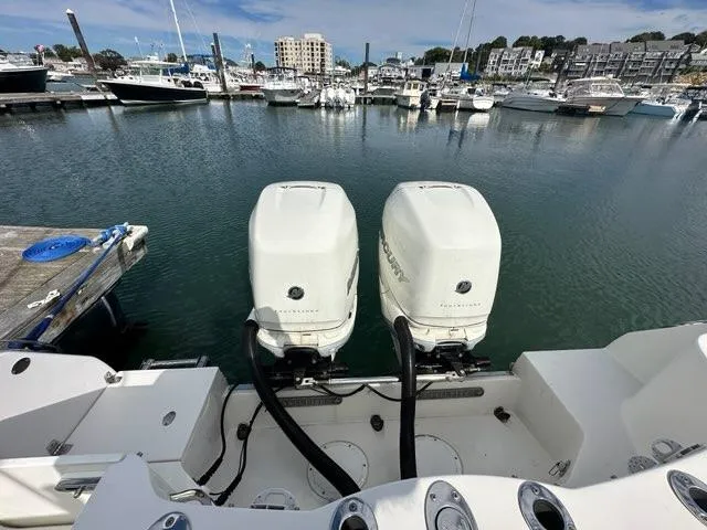 Slide: The Image of 2016 Sailfish 325 DC boat with twin outboard engines docked in a marina. - 26
