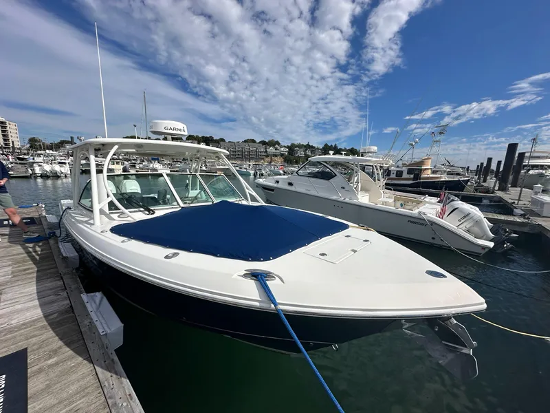 Slide: The Image of 2016 Sailfish 325 DC boat docked at a marina under a blue sky. - 27