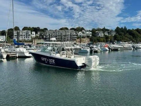Slide: The Image of 2016 Sailfish 325 DC boat in marina, surrounded by other boats and waterfront buildings. - 6