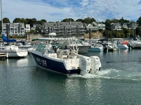 Slide: The Image of 2016 Sailfish 325 DC boat with twin engines in a marina setting. - 7