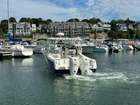 Slide: The Image of Sailfish 325 DC boat from 2016 navigating a marina with waterfront buildings in the background. - 8