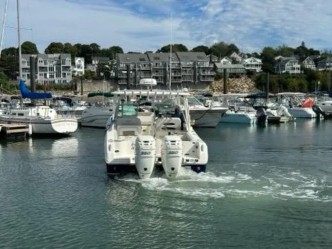 Slide: The Image of 2016 Sailfish 325 DC boat in a marina, surrounded by other boats and waterfront buildings. - 9
