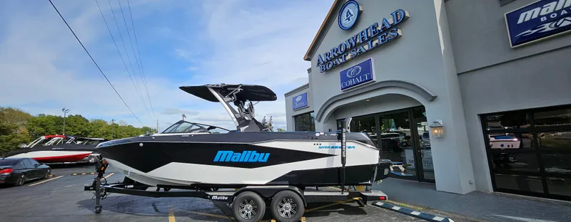Slide: The Image of 2025 Malibu 25LSV boat on trailer at Arrowhead Boat Sales dealership. - 1