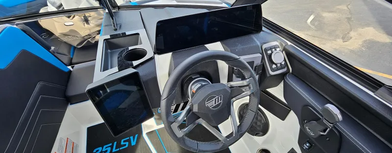 Slide: The Image of 2025 Malibu 25LSV boat dashboard with modern steering and digital displays. - 13